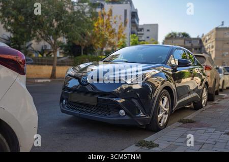 Toyota C-HR Hybrid. Petah Tikva, Israele, 13 settembre 2025, Una moderna auto nera parcheggiata in una strada in un quartiere urbano Foto Stock