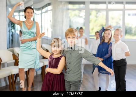 Danze classiche eseguite da bambini preadolescenti in abiti festivi Foto Stock