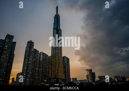 Il grattacielo Landmark 81 si erge illuminato al tramonto tra gli altri grattacieli di ho chi Minh City, Vietnam. Foto Stock
