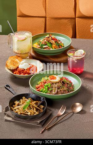 Delizioso e salutare pasto Gourmet impostato su Rustic Table, set di diversi piatti sul tavolo del ristorante, girato in studio Foto Stock