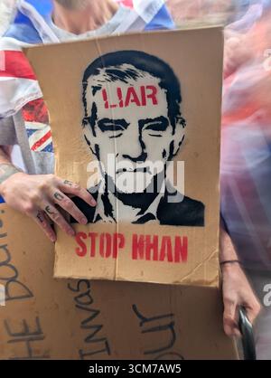 Londra, Regno Unito. 13 settembre 2025. Un manifestante regge un cartello con il volto del sindaco di Londra Sadiq Khan durante la marcia anti-immigrazione. Le persone detenevano bandiere dell' Unione e la Croce di San Giorgio durante una marcia unitaria del Regno guidata da Tommy Robinson . Credito: SOPA Images Limited/Alamy Live News Foto Stock