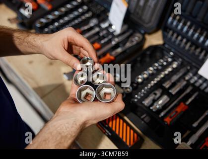 Un uomo sta afferrando con fermezza una collezione di varie prese nelle sue mani Foto Stock