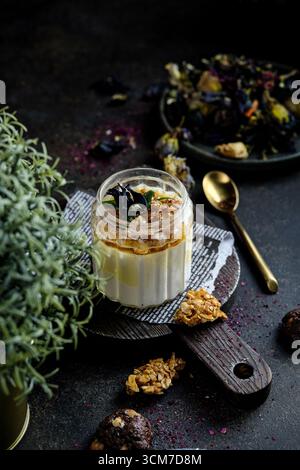 Concediti una ciotola di delizioso parfait di yogurt con muesli, noci e frutti di bosco Foto Stock