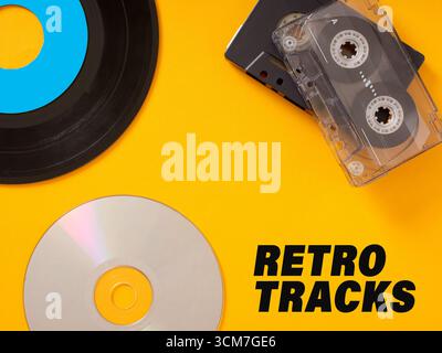 Registrazione in vinile, audiocassetta e cd che rappresentano l'evoluzione della tecnologia musicale su sfondo giallo con testo retrò Foto Stock