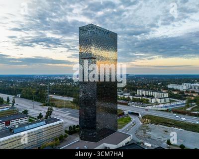 Kista, Stoccolma, Svezia - 7 settembre 2025: Scandic Victoria Tower vicino all'autostrada E4 e agli edifici commerciali, che riflettono il cielo serale Foto Stock