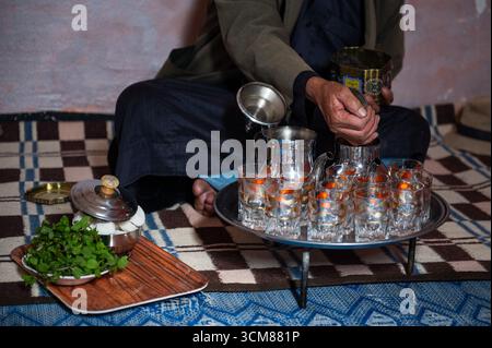 Uomo marocchino che versa il tradizionale tè verde nel bollitore Foto Stock