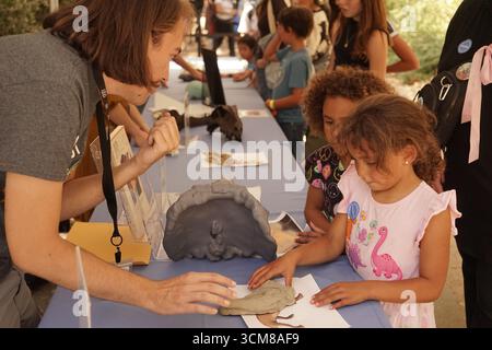 Los Angeles, Stati Uniti. 14 settembre 2025. I bambini interagiscono con un membro dello staff del Museo di storia naturale della contea di Los Angeles durante il decimo Dino Fest annuale a Los Angeles, negli Stati Uniti, 14 settembre 2025. Il museo ha aperto la sua decima edizione annuale del Dino Fest la domenica, attirando gli appassionati di dinosauri di tutte le età con rari reperti fossili, attività interattive e colloqui con i paleontologi più importanti. Crediti: Zeng Hui/Xinhua/Alamy Live News Foto Stock