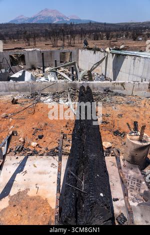 Una trave di legno carbonizzata nelle rovine di una capanna bruciata dopo l'incendio di Deer Creek nel sud-est dello Utah. Foto Stock