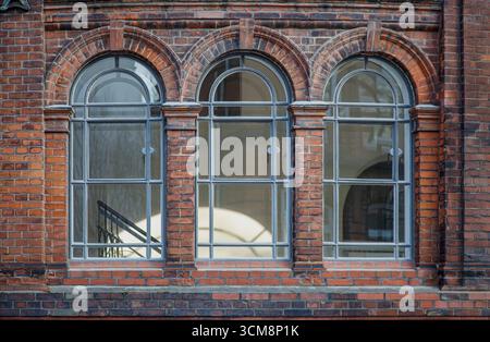 Tre finestre ad arco, dettagli architettonici di un edificio in mattoni Foto Stock