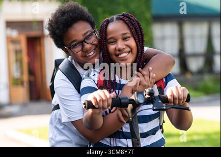 Ragazzi felici. Due adolescenti felici che guidano insieme uno scooter e sembrano soddisfatti Foto Stock