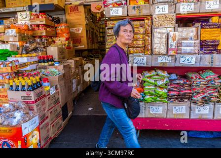 San Francisco, CALIFORNIA, USA, Senior Woman Walking Front of Local Food Store, Street Scenes, Chinatown, Daytime Foto Stock