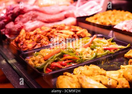 Diversi tipi di carne e verdura marinate in mostra al supermercato Foto Stock
