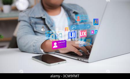 Designer che utilizza un computer portatile con progettazione UI UX e concetto di sviluppo di prodotti digitali, elementi dell'interfaccia utente, cliente, progettazione web creativa, app mobile de Foto Stock