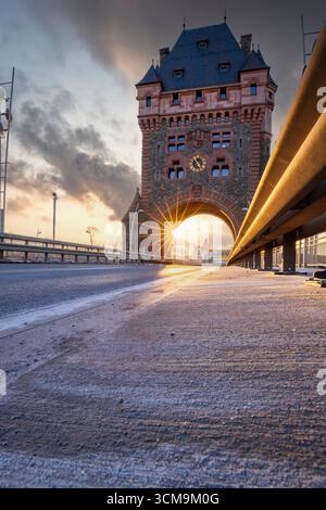 Nibelungen Bridge, la strada conduce attraverso un'antica porta storica della città, tramonta in serata sul Reno a Worms, Renania-Palatinato, Germania Foto Stock