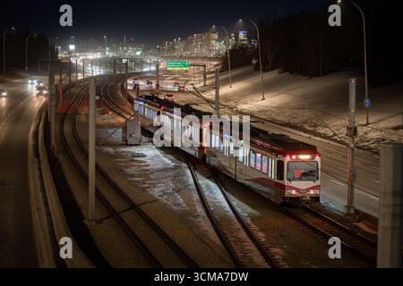 Calgary, Alberta Canada, 20 aprile 2025: Il treno di transito rapido percorre una media verso il centro città durante l'ora di punta serale. Foto Stock