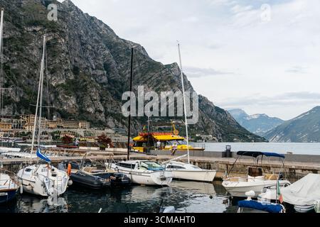 Limone sul Garda, Italia - 20 agosto 2025: Pittoresca veduta di Limone sul Garda, Italia, con le barche attraccate nel porto sullo sfondo di una montagna Foto Stock