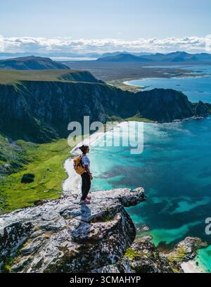 Spettacolari panorami si aprono dal monte Matind, mostrando la splendida costa di Bleik ad Andoya, Norvegia. Il sole proietta un caldo bagliore sulle acque cristalline, invitanti avventure ed esplorazioni. Foto Stock