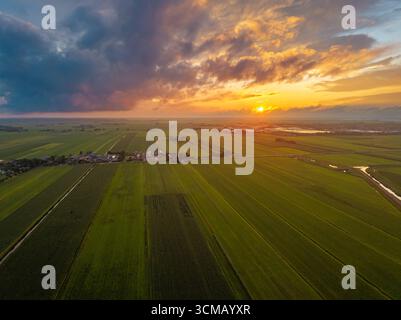 Tranquillo paesaggio olandese con ampi campi e un cielo luminoso all'ora d'oro. Foto Stock