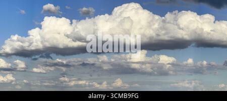 Nuvola di Stratocumulus al centro dell'immagine, fitta copertura nuvolosa di molte diverse nuvole di cumulus sullo sfondo, cielo azzurro luminoso sopra, interno Foto Stock