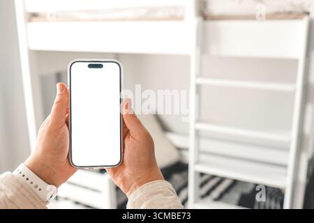 Telefono con schermo isolato nella stanza dei bambini sullo sfondo di un letto a castello, ordinare mobili. Foto Stock