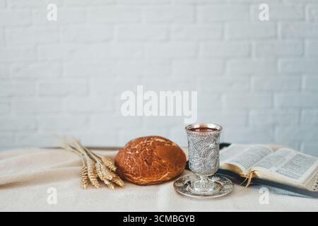 Vino, pane e bibbia aperta, concetto di comunione. Foto Stock