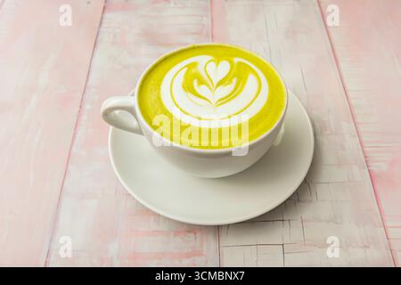 Delizioso tè verde matcha preparato in stile tradizionale in una ciotola, accanto alla polvere di matcha, un cucchiaio di bambù (chashaku) e una frusta Foto Stock