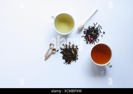 Layout creativo composto da una tazza di tè alle erbe su sfondo bianco. Vista dall'alto. Foto Stock