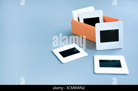 Supporto per telaio scorrevole in plastica bianca per pellicola per vetrini contenuto in una scatola di plastica arancione con sfondo semplice, nostalgia retrò, fotografia Foto Stock