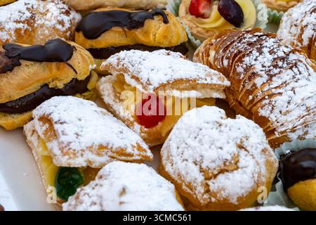 Varietà di dolci italiani dolci dolci dolci dolci dolci e torte con panna e frutta su piatto realizzati in panetteria artigianale a Roma, Italia, primo piano Foto Stock