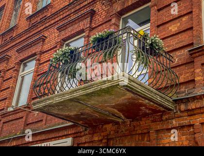 Ringhiera per balcone in ferro battuto. Facciata ristrutturata e decorata della casa storica con balcone decorativo in ferro in stile retrò. Appartamenti immobiliari Foto Stock