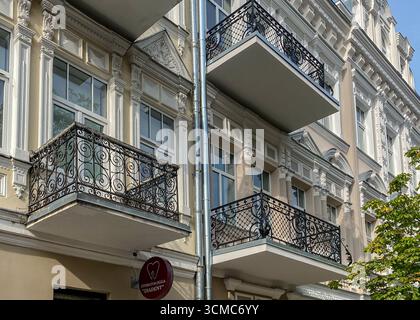 Ringhiera per balcone in ferro battuto. Facciata ristrutturata e decorata della casa storica con balcone decorativo in ferro in stile retrò. Appartamenti immobiliari Foto Stock