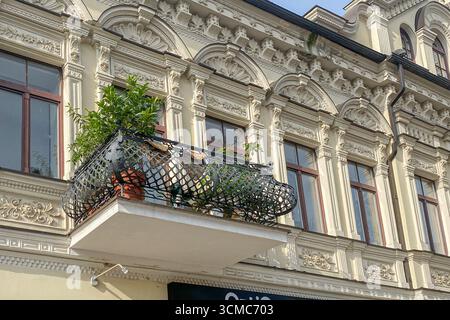 Ringhiera per balcone in ferro battuto. Facciata ristrutturata e decorata della casa storica con balcone decorativo in ferro in stile retrò. Appartamenti immobiliari Foto Stock