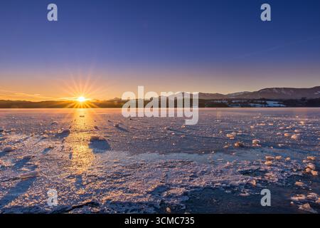 Lago ghiacciato con carri di ghiaccio nel paesaggio invernale durante l'Alba, Baviera, Germania, Europa Foto Stock