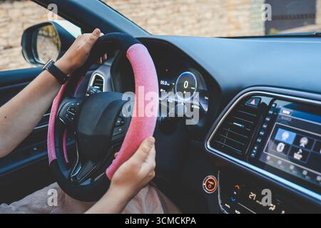 Ragazza che guida un'auto elettrica. Foto Stock