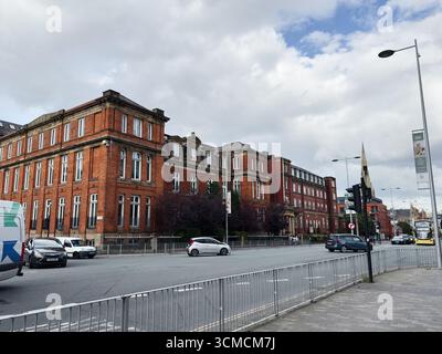 Salford, Regno Unito - 12 settembre 2025: Una vista di un edificio storico Salford Royal Hospital in Chapel Street a Manchester, Regno Unito, con attività circostanti. Foto Stock