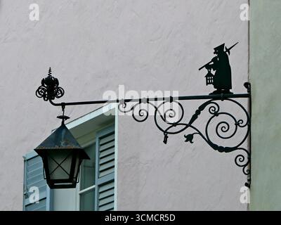 Lampada da strada in ferro battuto con figurina da favola sul muro dell'edificio nell'affascinante cittadina medievale di chiusa, in alto Adige Foto Stock