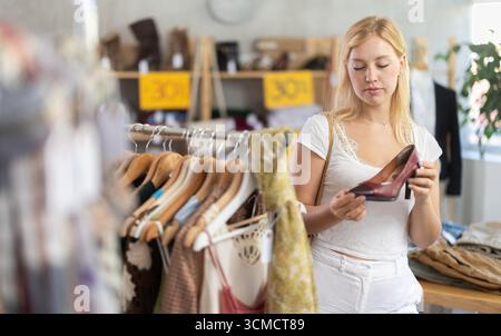 Donna che sceglie scarpe alla moda in vendita Foto Stock
