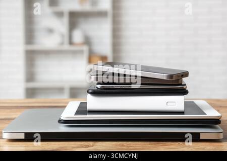 Una pila di gadget moderni su un tavolo di legno in officina Foto Stock