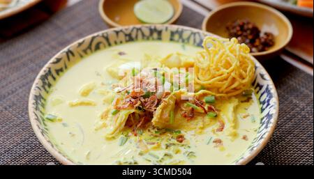 Tagliatelle al curry Khao Soi tailandesi in una ciotola decorativa. L'autentica Chiang mai Foto Stock
