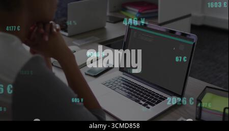 Uomo afroamericano adulto maturo che si concentra sul codice sul laptop alla scrivania, con smartphone, spazio di copia Foto Stock