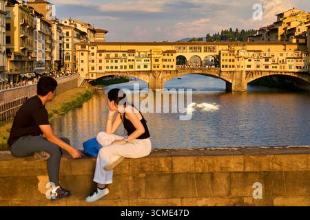 Coppia al tramonto, Ponte Vecchio, Ponte Santa Trinita, fiume Arno, Firenze, Toscana, Italia Foto Stock
