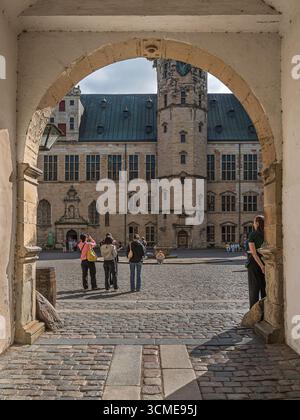 Turisti in un arco sul cortile interno del castello di Kronborg a Elsinore, Danimarca, agosto 2025 Foto Stock
