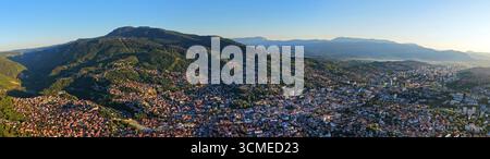 Ampia vista panoramica con drone della città di Sarajevo e del monte Trebevic sotto il cielo azzurro durante l'estate Foto Stock