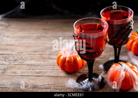 Primo piano di una bevanda a tema Halloween servita in spaventosi occhiali a mano con scheletro Foto Stock