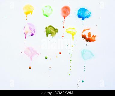 spruzzi di colore gocciolano su sfondo bianco Foto Stock