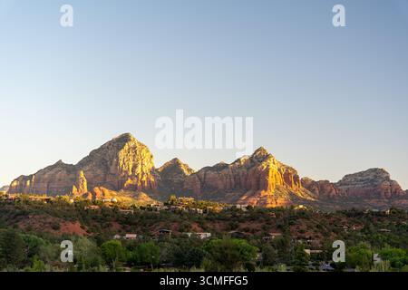 Il tramonto dorato illumina le formazioni rocciose rosse di Sedona e il paesaggio panoramico del deserto Foto Stock