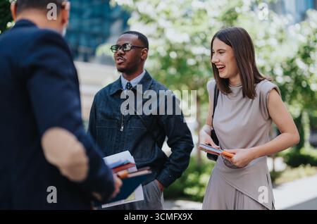 Gruppo di persone che si impegnano in una conversazione amichevole all'aperto Foto Stock