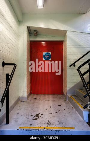 Londra Regno Unito, 16 settembre 2025, Red Painted Internal Fire Escape Door Foto Stock