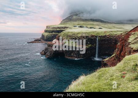 La cascata di Gasaladur si tuffa nell'Oceano Atlantico vicino al villaggio di Gasadalur, alle Isole Faroe Foto Stock