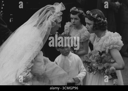 Ospiti reali al St. Margaret's Wedding. Le immagini mostrano: Dopo il suo matrimonio la sposa si fermò a parlare con i suoi assistenti nuziali mentre lasciava la Chiesa. I membri della famiglia reale indossavano oggi, martedì, a St. Margaret's, Westminster, figlia di Sir Harold e Lady Ziz Wernher di Thorpe Lubenham, Hall Market Harborough, era sposata con il maggiore David Butter, M.C., le guardie scozzesi. Alla presenza della sposa c'erano la principessa Alessandra di Kent e il suo giovane fratello, il principe Michele. 5 novembre 1946 Foto Stock